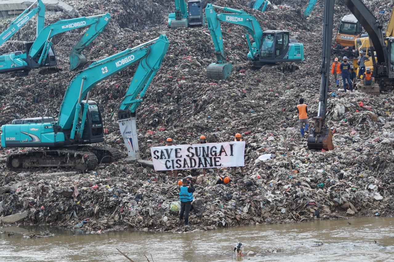 Tampak dari kejauhan para Aktivis lingkungan menggelar aksi nekat menguburkan dirinya di bawah sampah yang menggunung di Tempat Pembuangan Akhir (TPA) Cipeucang, Serpong, Tangerang Selatan, Sabtu (30/5/2020).