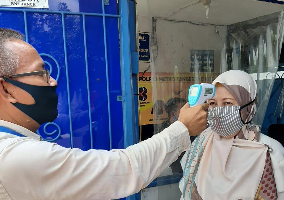 Pemohon SIM mengikuti protokol kesehatan dengan mencuci tangan menggunakan cairan anti virus sebelum memasuki area Satpas SIM Polres Metro Tangerang Kota.