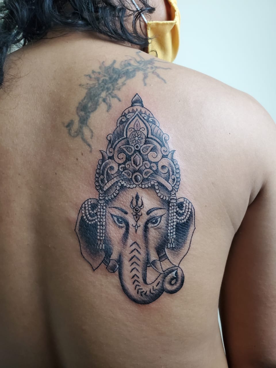 Seniman tato di NiceArt Tattoo Studio, Kota Tangerang, mengenakan masker dan face shield untuk menjamin kesehatan pelanggan saat pandemi COVID-19, Rabu (24/6/2020).