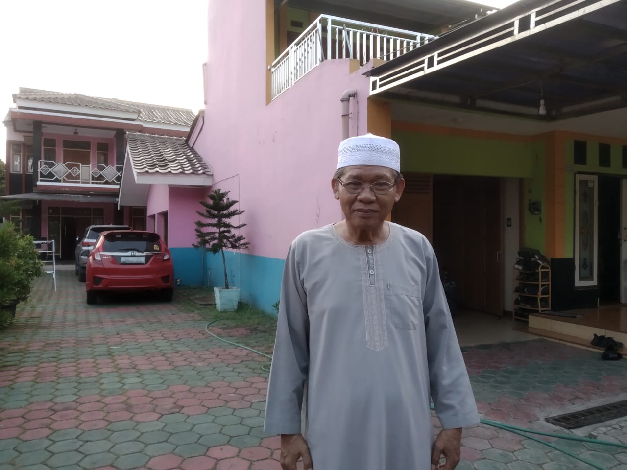 Durahman sedang duduk di halaman rumah di sore yang sejuk.