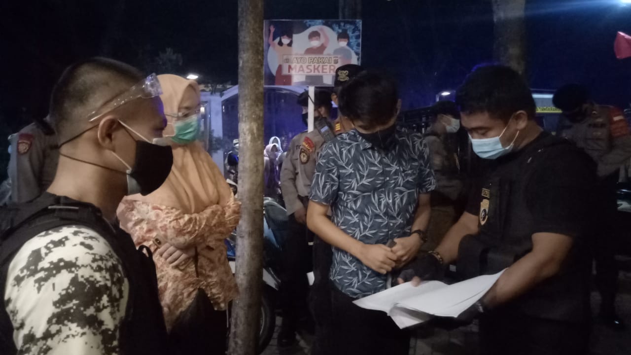 Personel Satpol PP Tangsel saat menindak pengelola kafe yang melanggar PSBB yang berlokasi di Jalan Camat, Ciater, Serpong, Tangerang Selatan, Jumat (25/9/2020) malam.