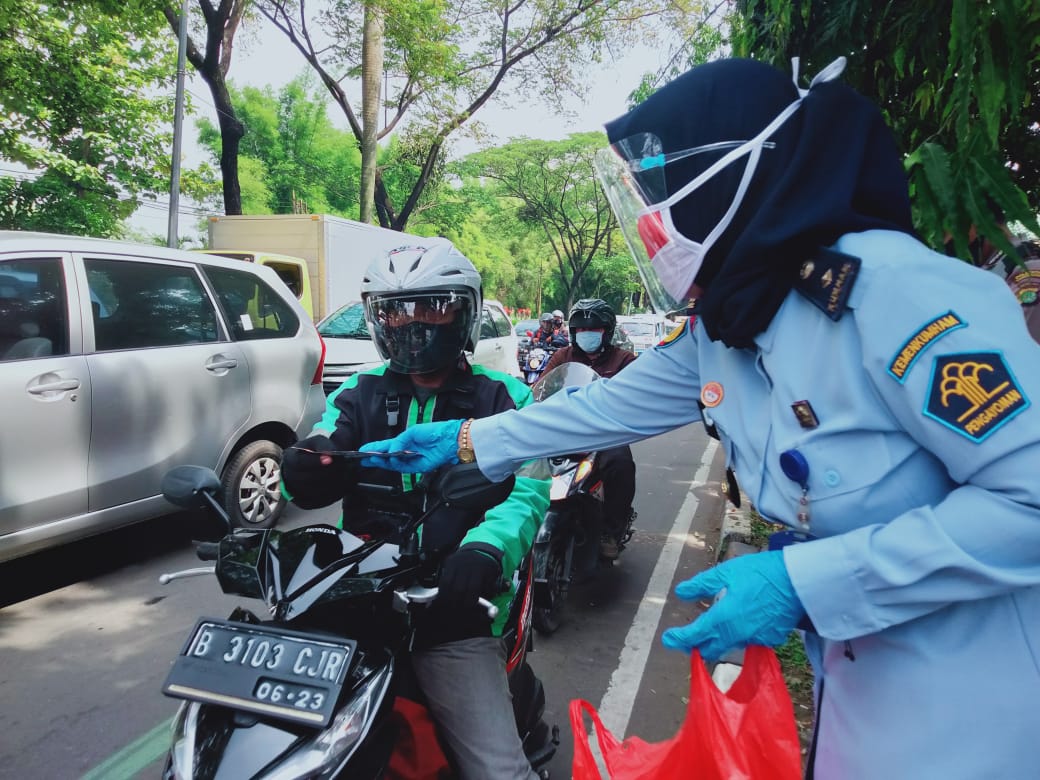 Petugas Lapas Perempuan kelas IIA Tangerang membagikan masker kepada warga disekitaran tugu Adipura Kota Tangerang, Rabu (21/10/2020).