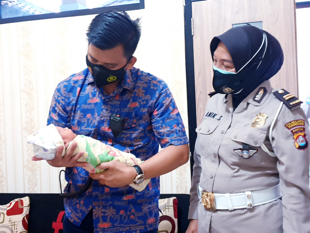 Petugas Kepolisian saat mengendong bayi mungil yang ditemukan warga, di dalam kardus kemasan air mineral di Kampung Kaliasin, Desa Kaliasin, Kecamatan Sukamulya, Kabupaten Tangerang, Kamis (22/10/2020).