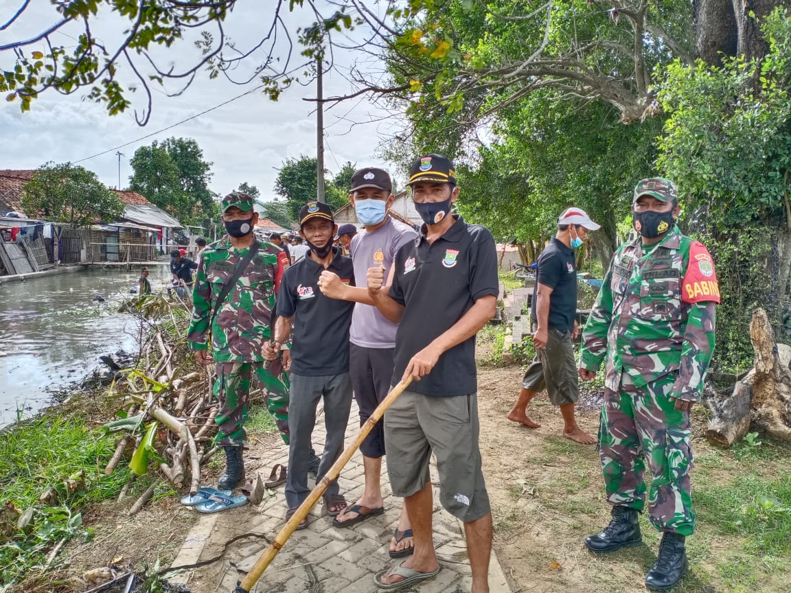 Kegiatan aksi gotong royong membersihkan saluran irigasi di desa kampung melayu barat, Kecamatan Teluknaga, Minggu (13/12/2020).