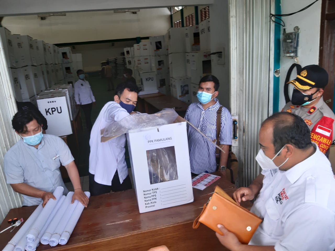 Sejumlah Komisi Pemilihan Umum (KPU) di dampingi Anggota kepolisian saat mengeluarkan hasil pilkada Tangsel di Gudang Serba Guna Kecamatan Pondok Aren, Tangsel, Senin (25/1/2021).