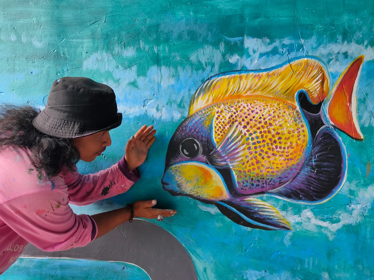 Seniman yang melukis di tembok kampung-kampung tematik yang ada di Kota Tangerang.
