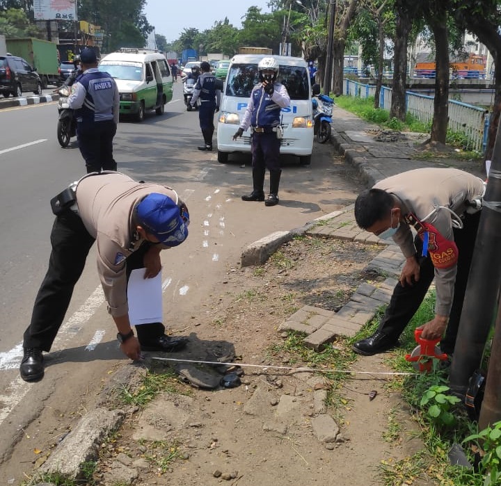 Anggota kepolisian saat olah tkp insiden kecelakaan di Jalan Daan Mogot dekat Pusat Niaga, Batuceper, Kota Tangerang pada Senin (19/4/2021) sekitar pukul 12.00 WIB.