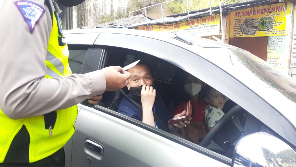 Anggota kepolisian saat memberhentikan satu unit kendaraan pribadi di Pos Penyekatan yang berlokasi di wilayah Bitung, Kabupaten Tangerang, Kamis (6/5/2021).