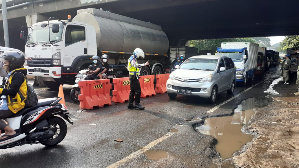 Anggota kepolisian saat mengatur lalu linta serta mengontrol kegiatan masyarakat, terutama dalam mencegah kegiatan mudik. Jumat (7/5/2021).