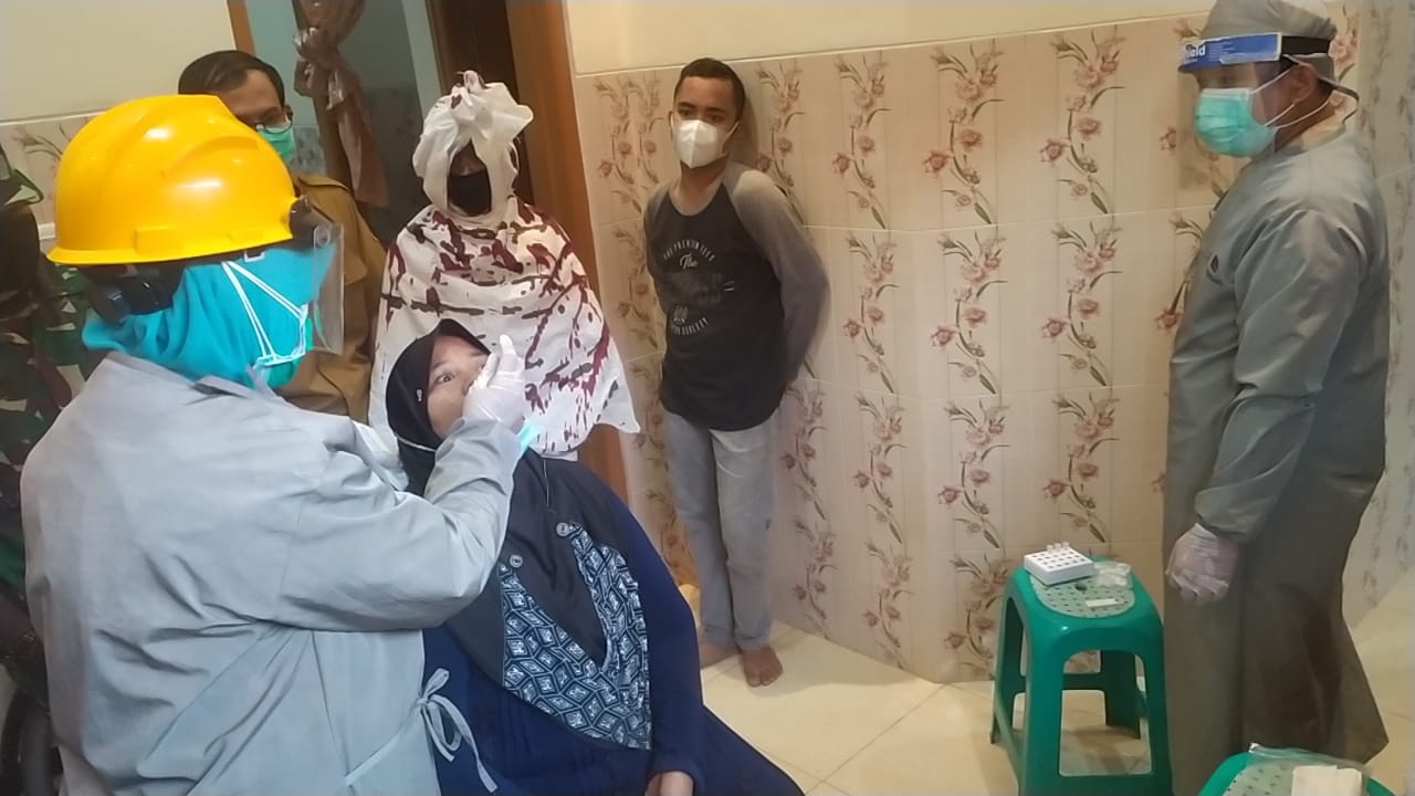 Salah satu warga saat di Tes Antigen guna mencegah penyebaran COVID-19 yang di hadiri sesosok 'pocong' terbungkus kain kafan, terlihat gentayangan di wilayah Kecamatan Setu, Tangerang Selatan, Senin (17/5/2021).