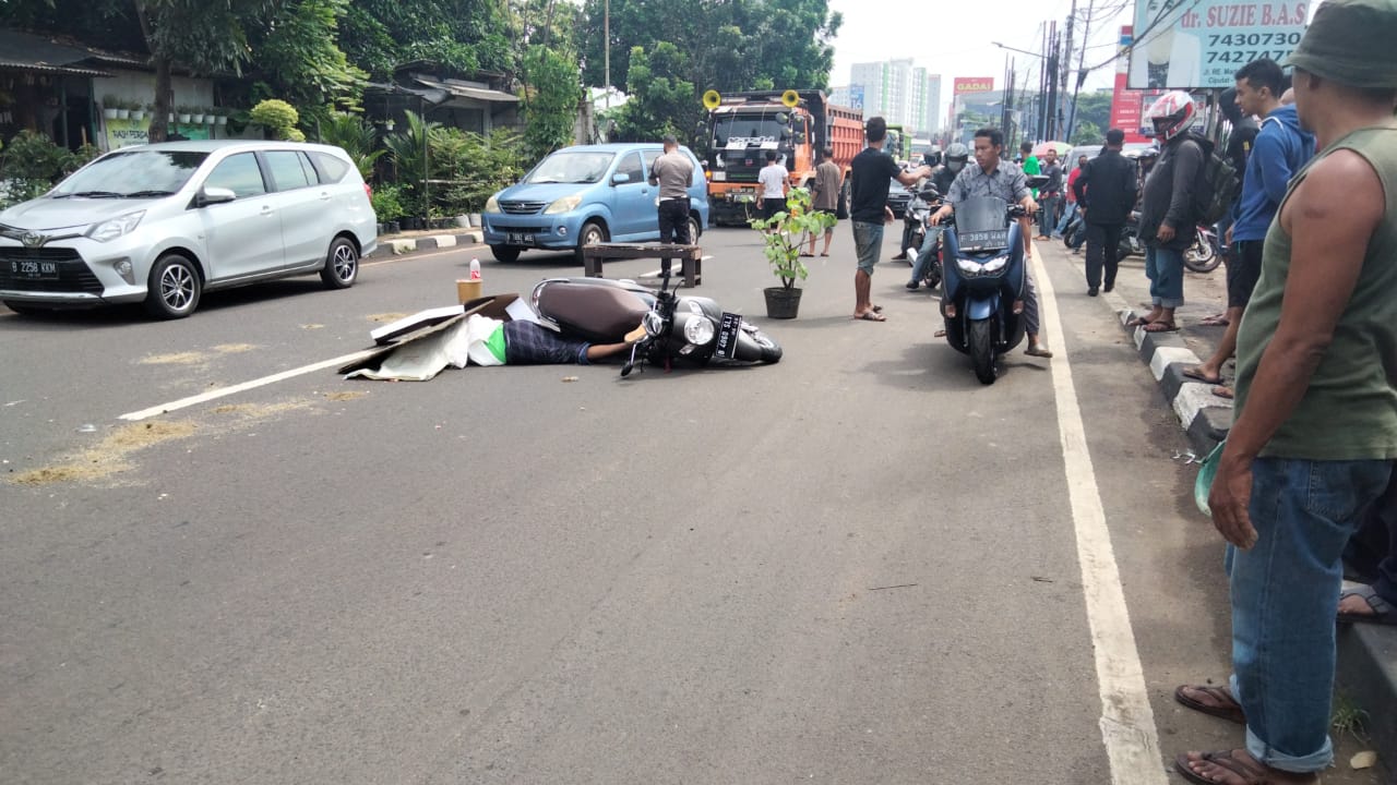 Seorang pria Rokib Rival, 51 terkapar ditengah jalan terkait kecelakaan maut antara pemotor dan Bus Transjakarta di Jalan RE Martadinata, Cipayung, Ciputat, Tangerang Selatan, Selasa (18/5/2021).