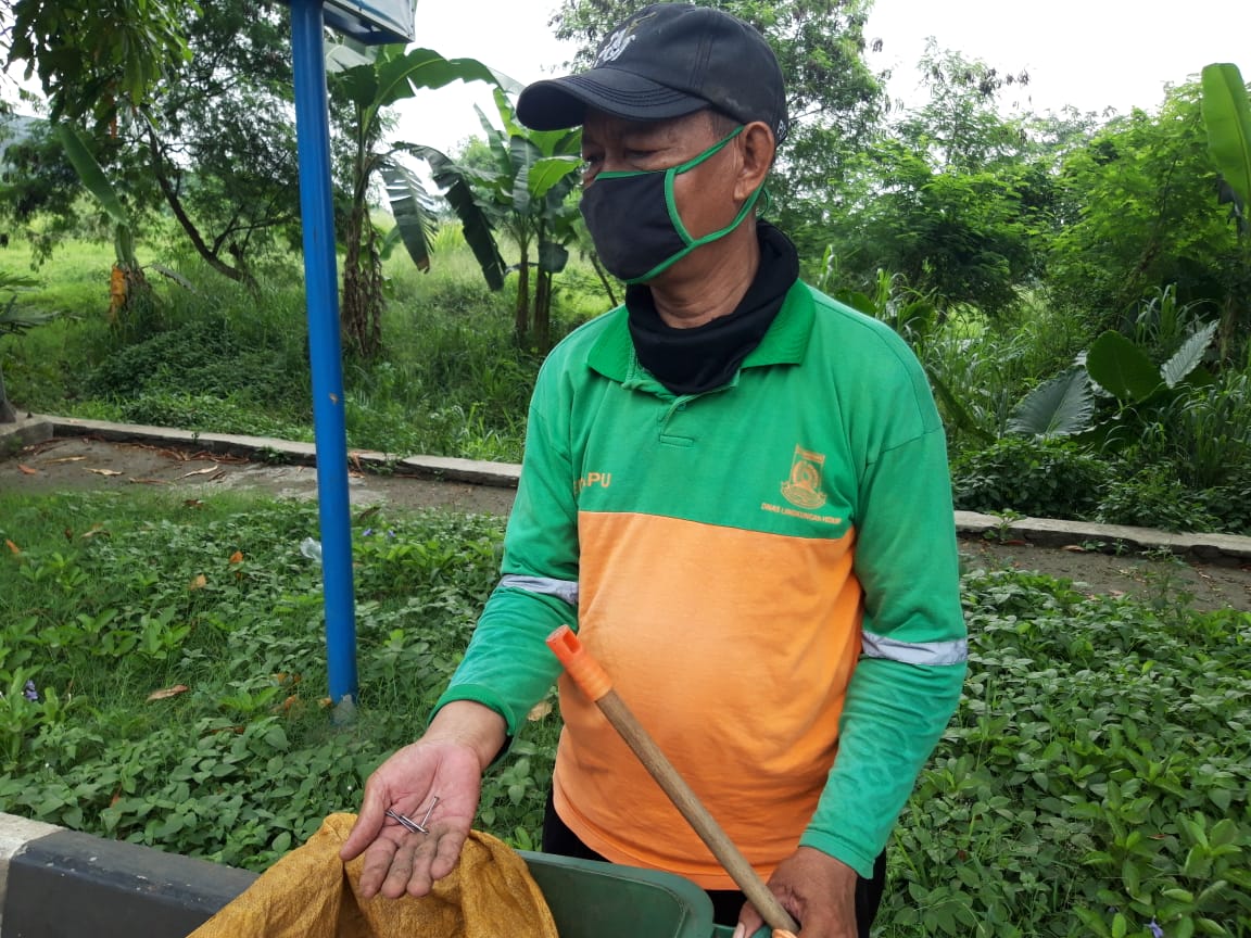 Petugas kebersihan saat menemukan beberapa jumlah paku di Jalan Jenderal Sudirman, Kecamatan Tangerang, Kota Tangerang, Senin (24/5/2021).