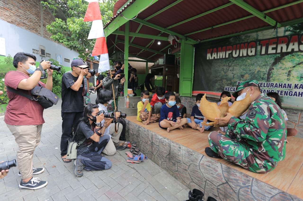 Komunitas Taman Potret (Kotret) menunjukan ekistensi memotret dengan objek beberapa jumlah anak kecil dan Anggota TNI di hadapanya dalam rangka memperingati hari lahir Pancasila di kampung teras Pancasila, Karang Tengah, Kota Tangerang, Senin 1 Juni 2021.