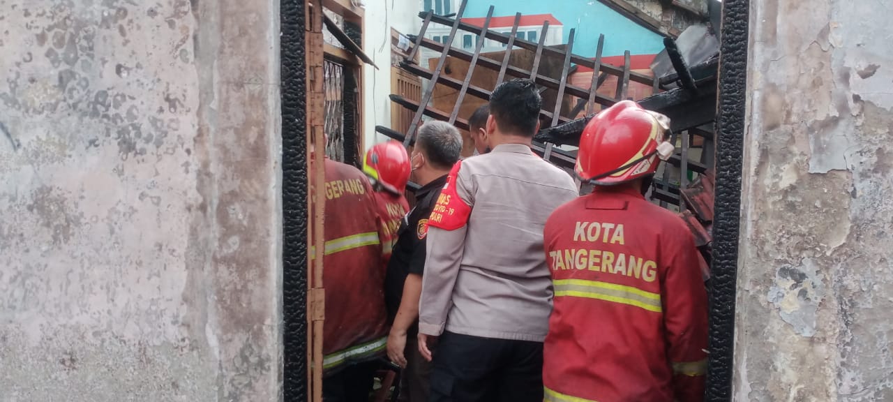 Petugas pemadam kebaran dan anggota kepolisian saat berada di lokasi terjadinya kebakaran.