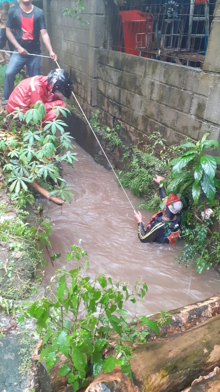 Warga di kawasan Jalan Kampung Gunung Indah 4 RT 04 RW 01, Cireundeu, Ciputat saat mencoba mencari bocah yang terseret arus saluran air, Tangerang Selatan, Kamis, 10 Juni 2021.