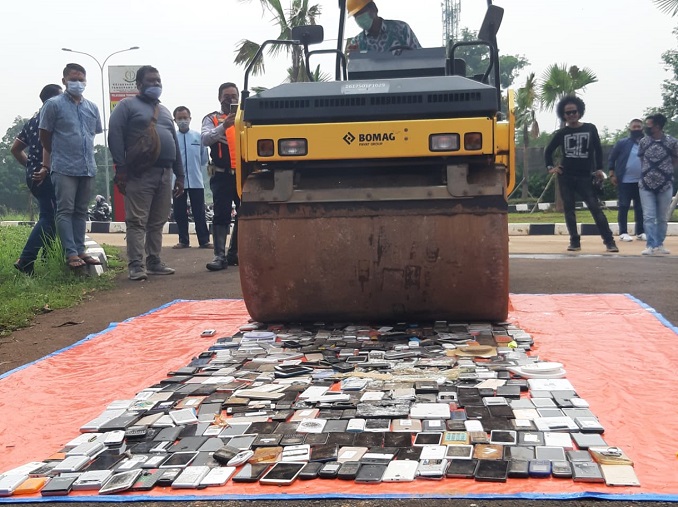 	Barang bukti puluhan smartphone saat di hancurkan menggunakan kendaraan berat jenis Tendem Roller di Kantor Kejaksaan Negeri (Kejari) Kota Tangerang Selatan, Kamis, 17 Juni 2021.