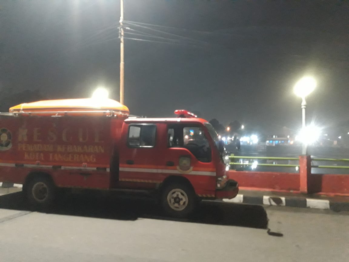 Satu unit mobil pemadam kebakaran berada di lokasi kejadian bunuh diri di pinggiran Sungai Cisadane, Kota Tangerang, Kamis 1 Juli 2021 malam.