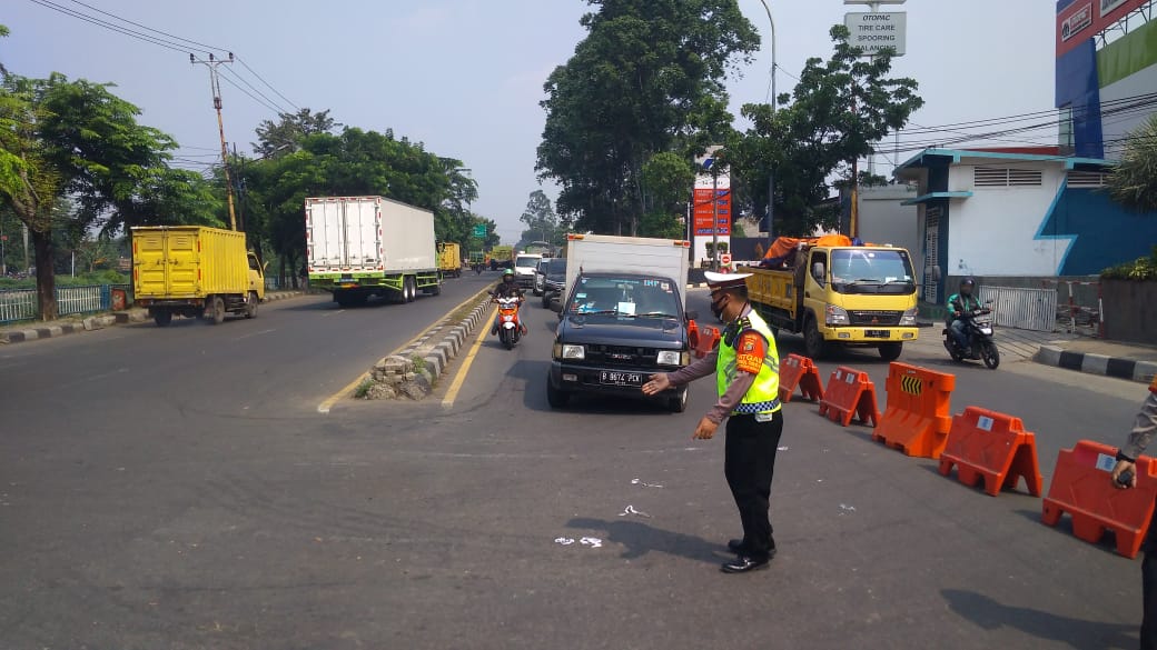 Petugas Polres Metro Tangerang Kota memutar balik ratusan kendaraan ke arah asal di Jalan Daan Mogot, Senin 5 Juli 2021.