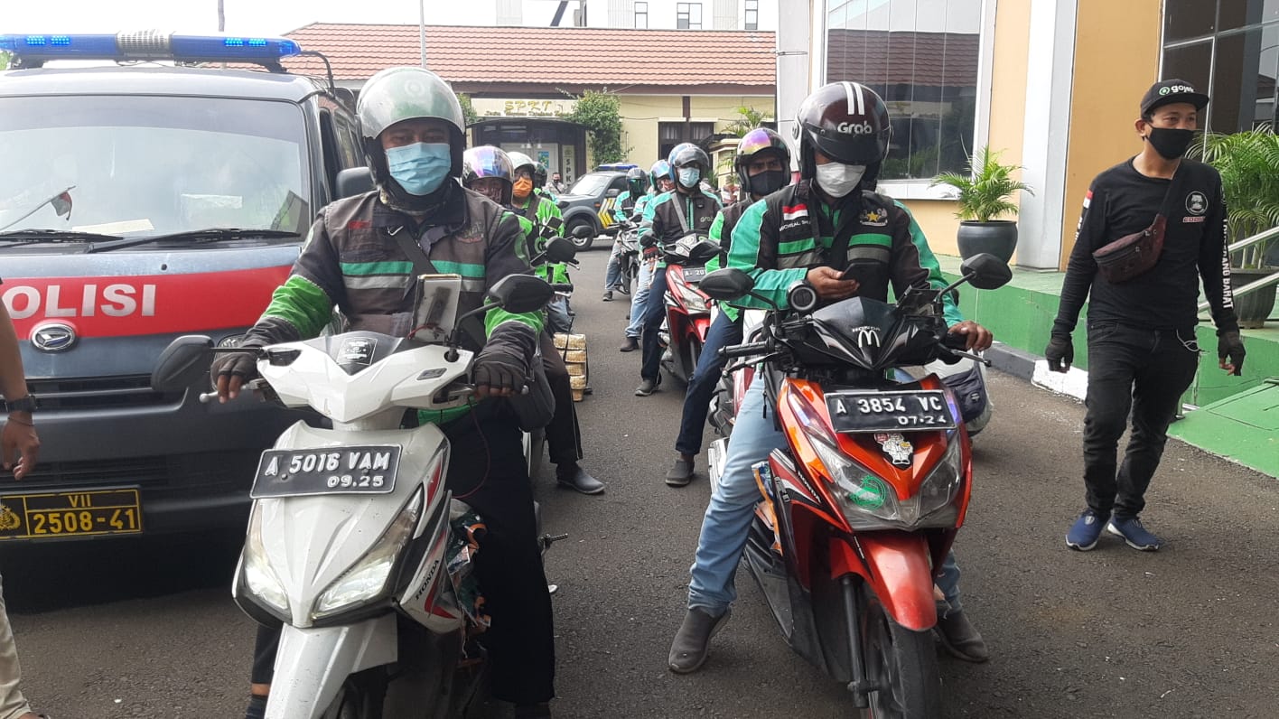 Kapolres Tangsel AKBP Iman Imanuddin menyerahkan ratusan paket sembako dan daging melalui driver ojek online kepada penerima untuk dibagikan kepada masyarakat Tangerang Selatan, Selasa 20 Juli 2021.