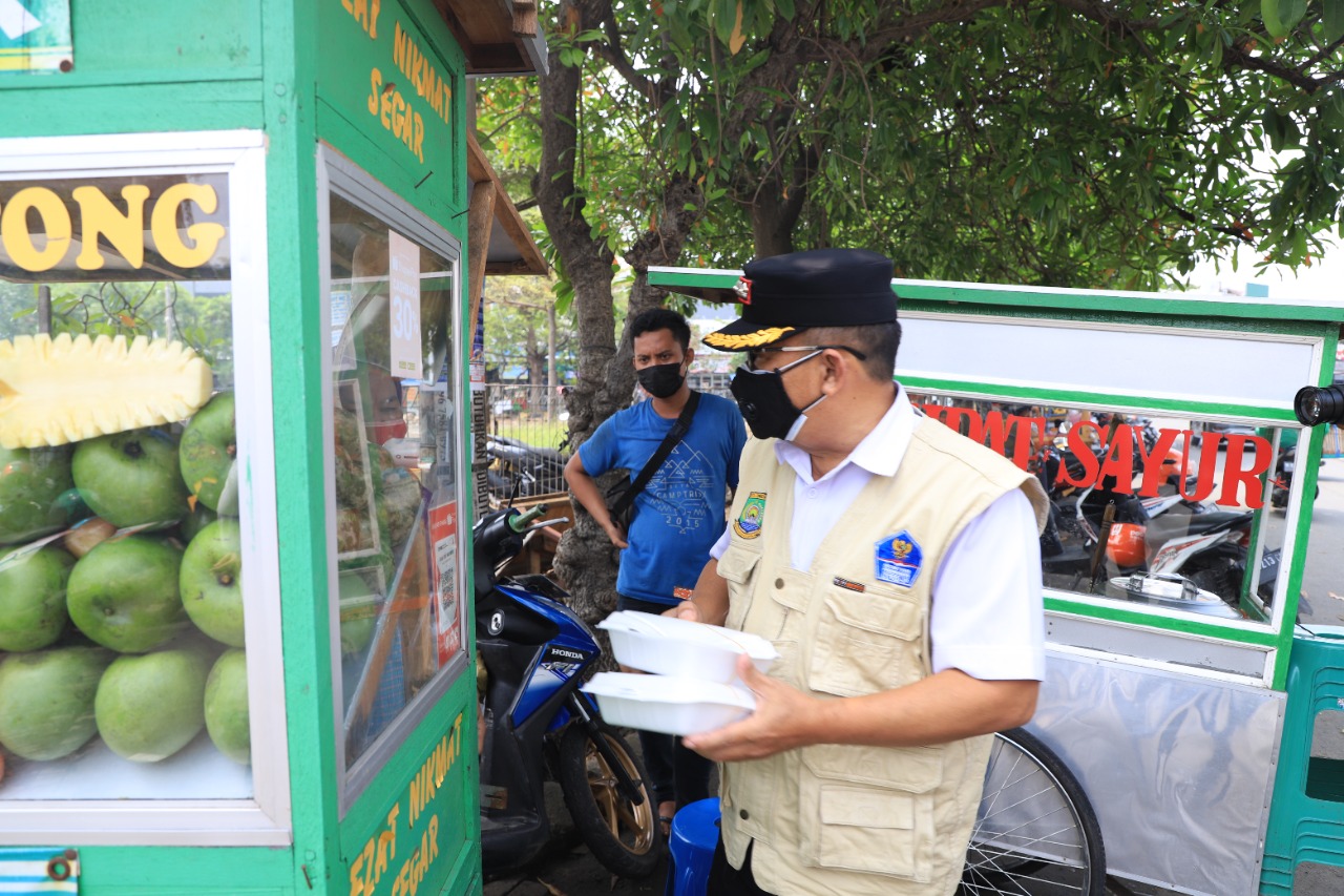 Rahmat Hendrawijaya Camat Batuceper berbagi sembako dan paket makan siang terhadap pedagang di Kecamatan Batuceper saat melakukan penertiban PPKM di kawasan perdagangan Poris Gaga, Kota Tangerang.