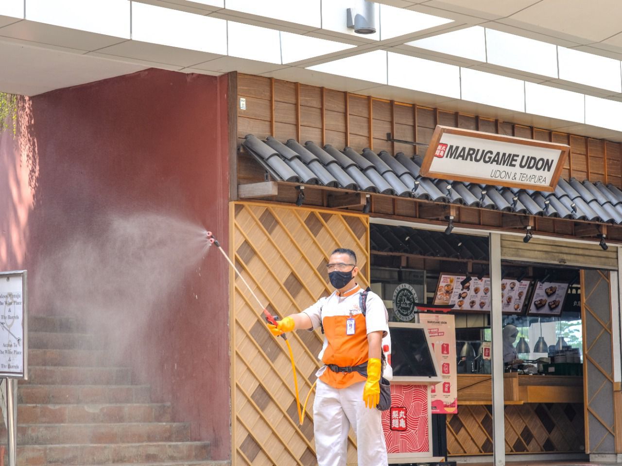 Pegawai mal summarecon serpon saat menyemprotkan cairan disinfektan di area summarecol mal Serpong.