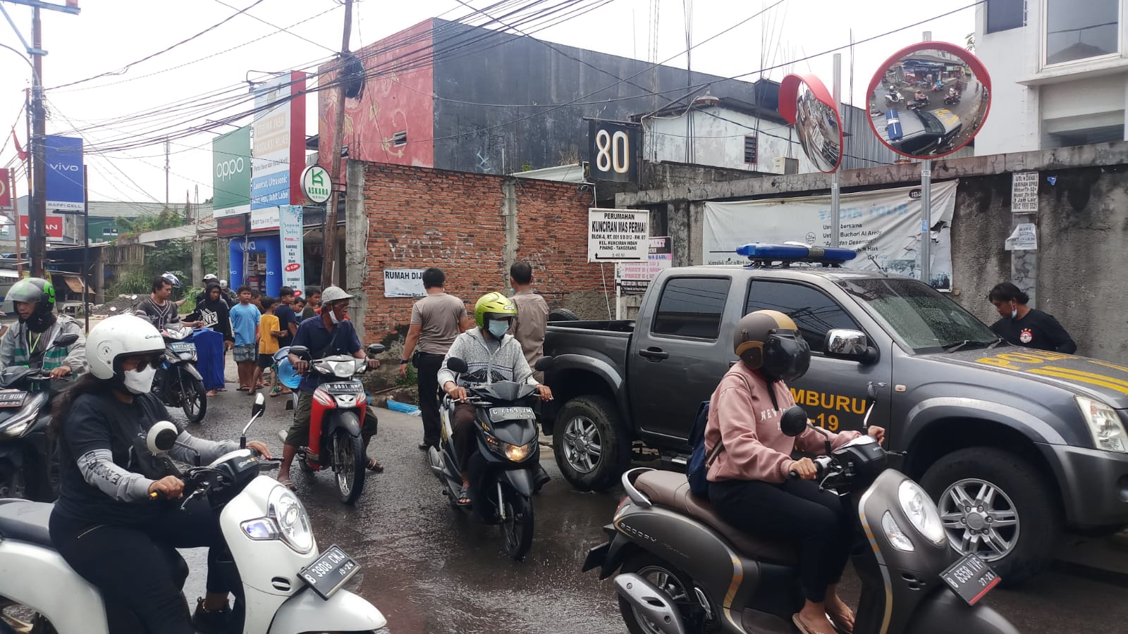 	Suasana warga yang memadati insiden satu unit mobil pikap terperosok kedalam saluran air di Jalan Sultan Ageng Tirtayasa, Kelurahan Kunciran Indah, Kecamatan Pinang, Kota Tangerang, Senin 27 September 2021 siang.