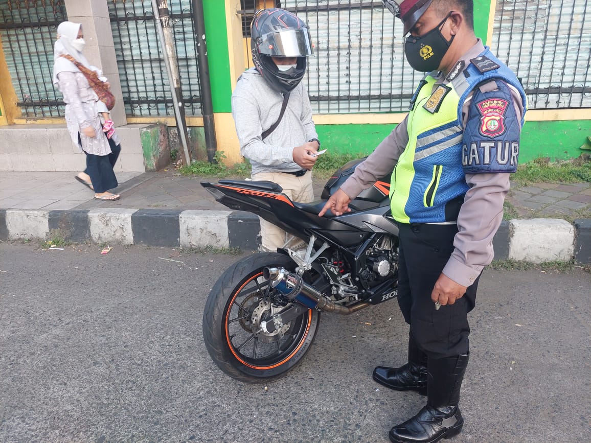 Anggota kepolisian saat menindak pengendara Sepeda Motor yang menggunakan knalpot bising di Kota Tangerang berupa tilang, Selasa 5 Oktober 2021.