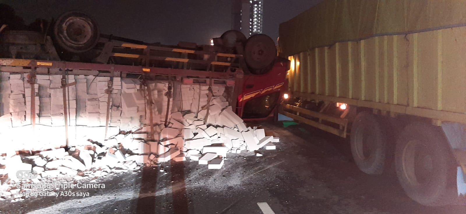 	Satu unit truk bermuatan hebel terbalik di KM 16 lajur Tangerang arah ke Tomang, Kamis 21 Oktober 2021.