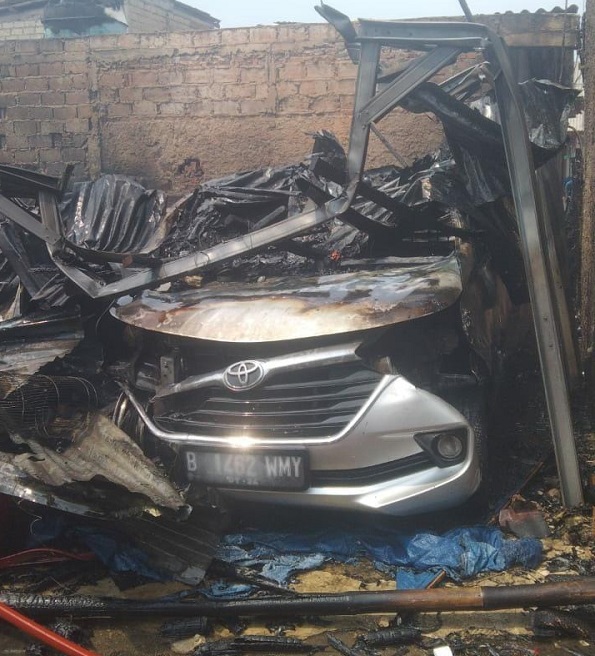 Satu unit mobil Nissan Livina yang tertimpa reruntuhan bangunan atap rumah selepas kebakaran.