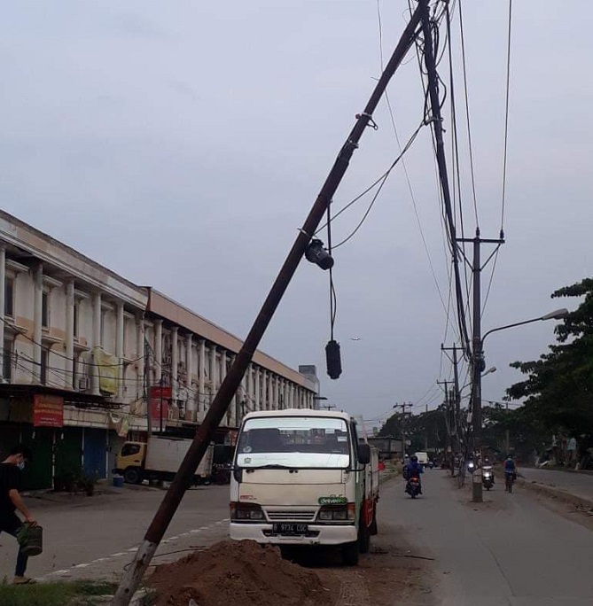 Sejumlah tiang listrik PLN dan tiang Telkom yang doyong dengan kabel-kabel semrawut dan menjuntai hingga ke jalanan di Jl Raya Perancis, Kabupaten Tangerang, Jumat ini, 7 Januari 2022