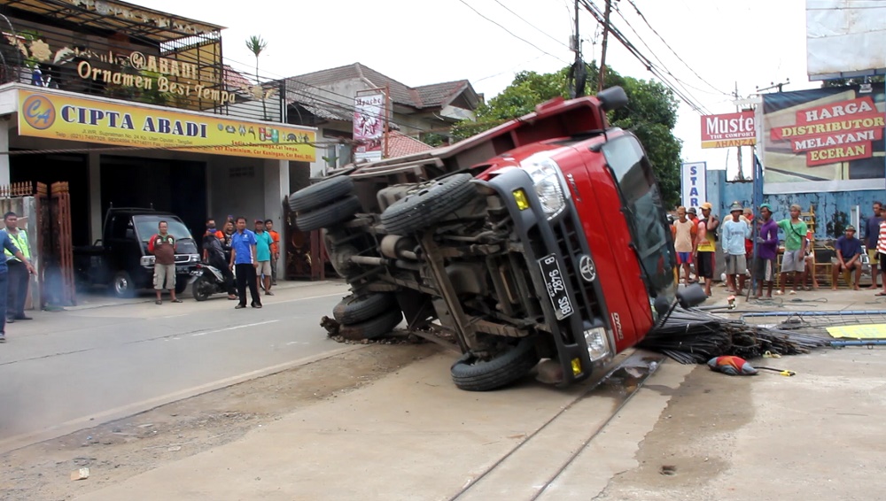 Truk Bermuatan Besi Beton Terguling Di Kampung Hutan