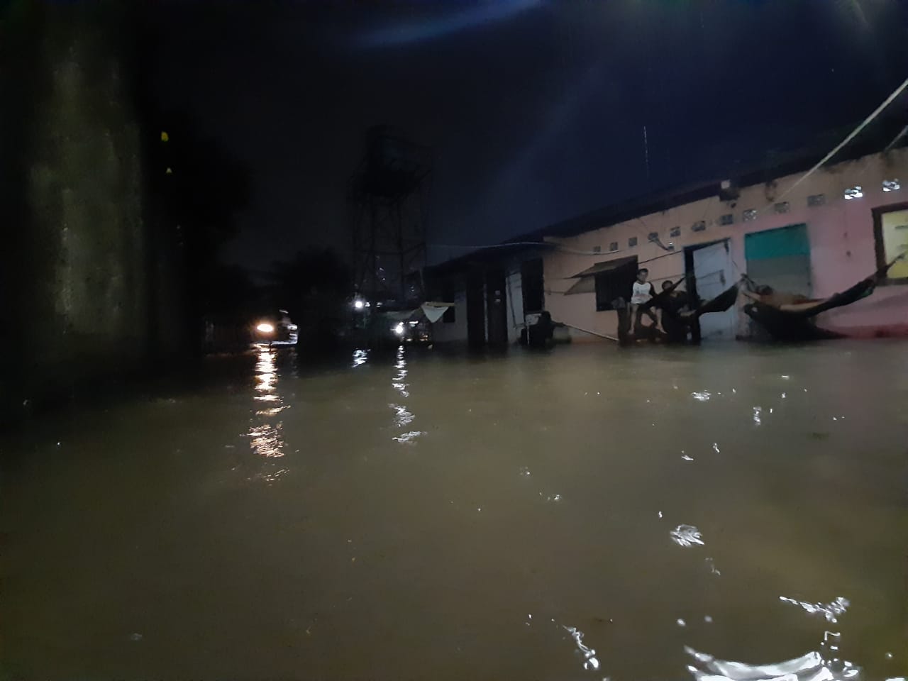 Seorang warga yang terendam banjir di Jalan Bukit Raya Serua Indah RT 01 RW 09 Kelurahan Serua Indah Kecamatan Ciputat, Kota Tangsel, Minggu (26/4/2020).
