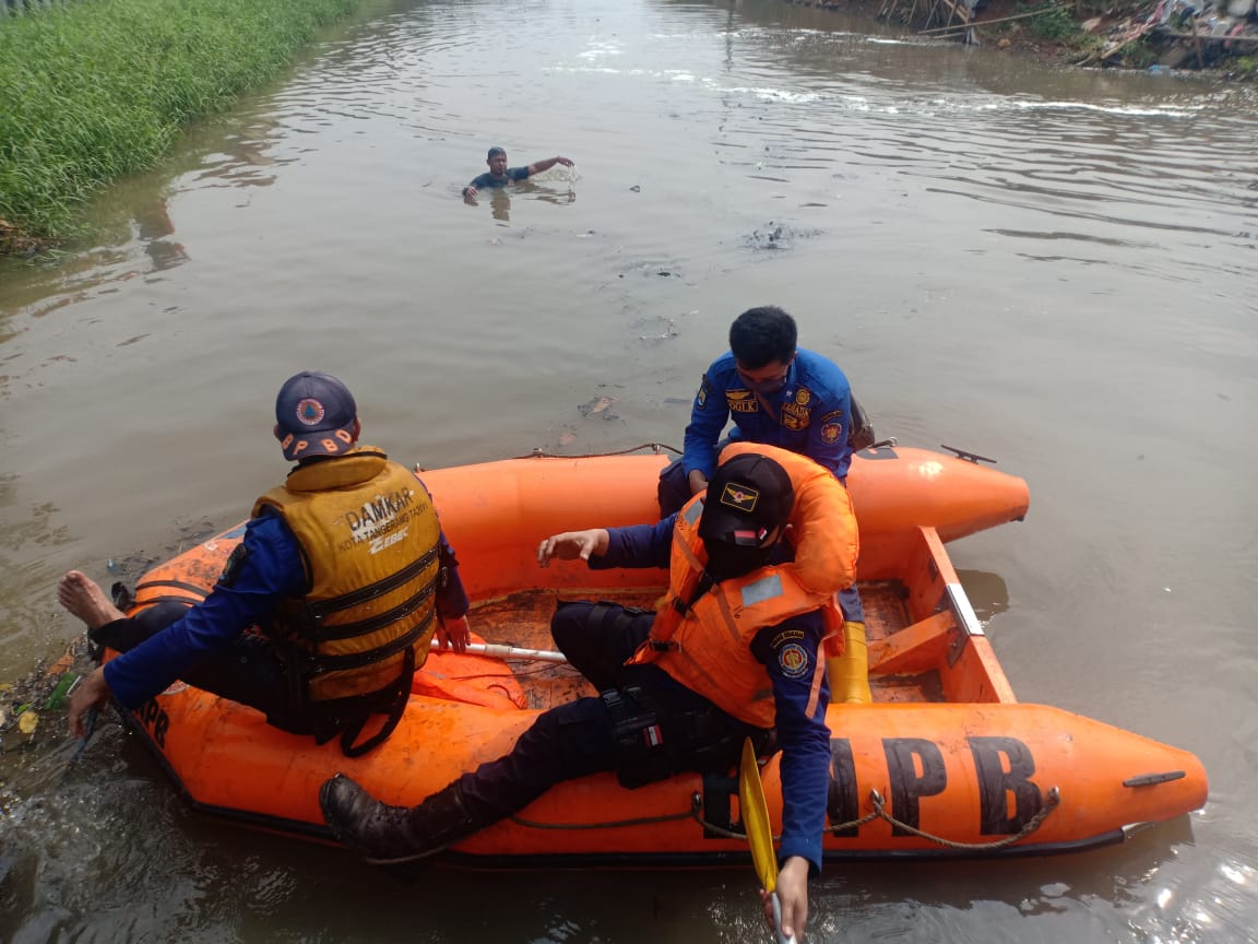 Personel BPBD Kota Tangerang berusaha mencari bocah yang tenggelam di sungai Ledug.