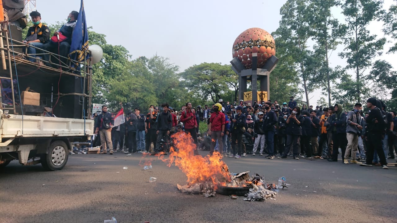 Ribuan mahasiswa dari berbagai kampus di Kota Tangerang menunjukan aksinya dengan cara membakar ban di Tugu Adipura, Jalan Veteran, Kota Tangerang, Rabu (7/10/2020).