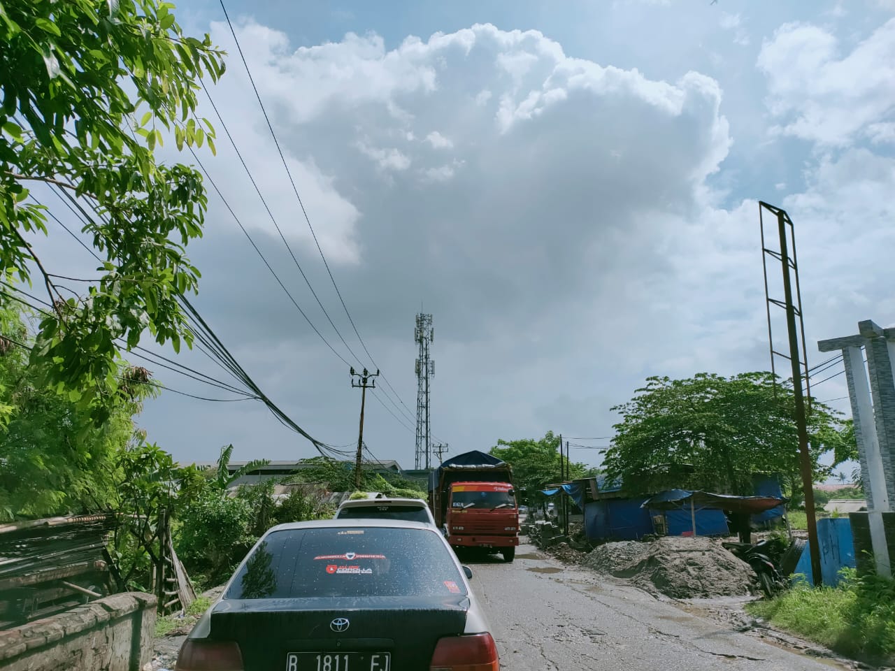 Suasana proyek perbaikan jalan di ruas Jalan Raya Pasar Kemis, Kampung Cilongok, tepatnya di depan Situ Cilongok, Kecamatan Pasar Kemis, Kabupaten Tangerang, Selasa (8/12/2020).