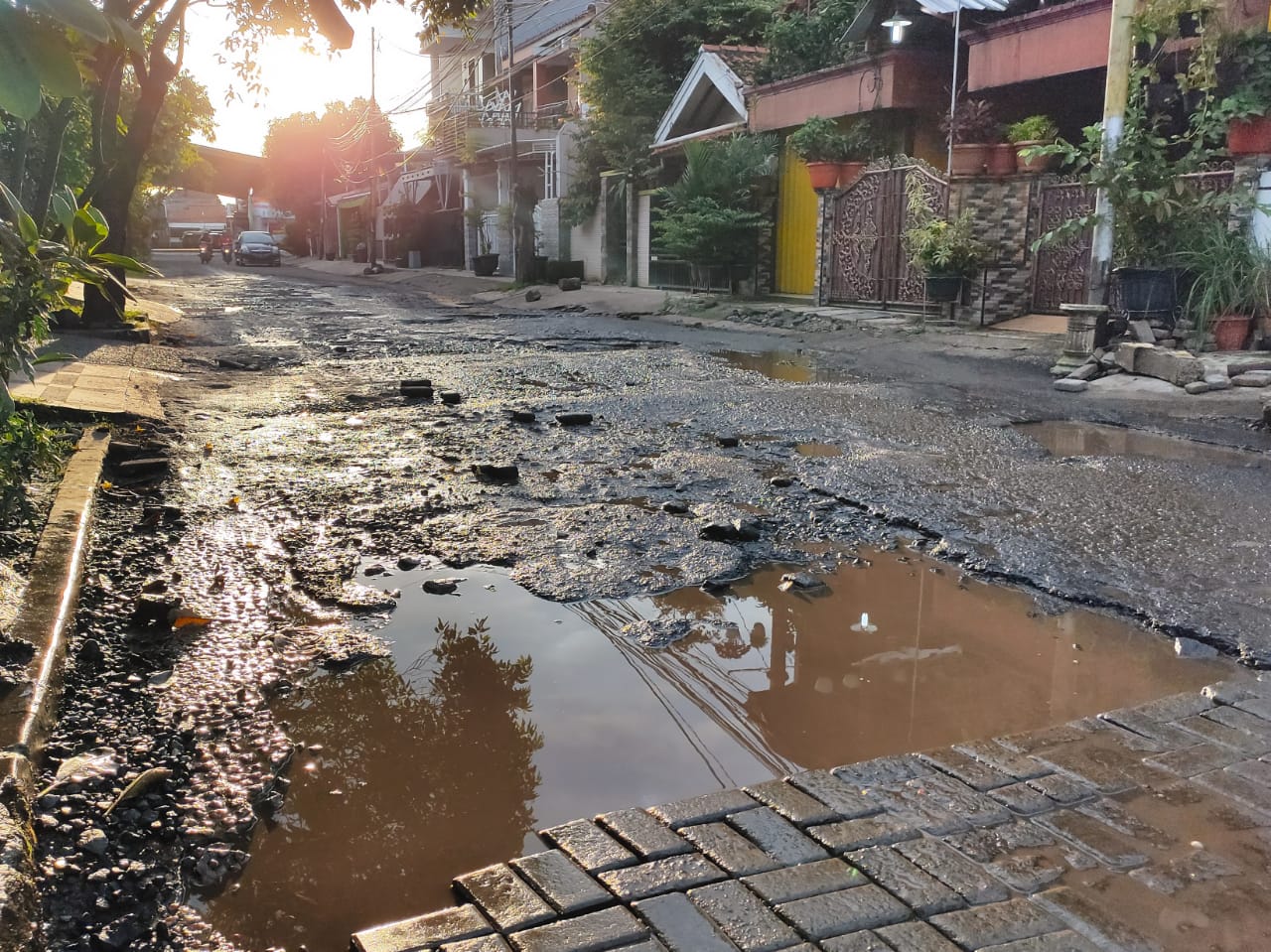 Jalan yang berlubang berlokasi di Kompleks Perumahan Sekneg, Kebon Nanas, Kecamatan Pinang, Kota Tangerang, Jumat (19/02/2021).