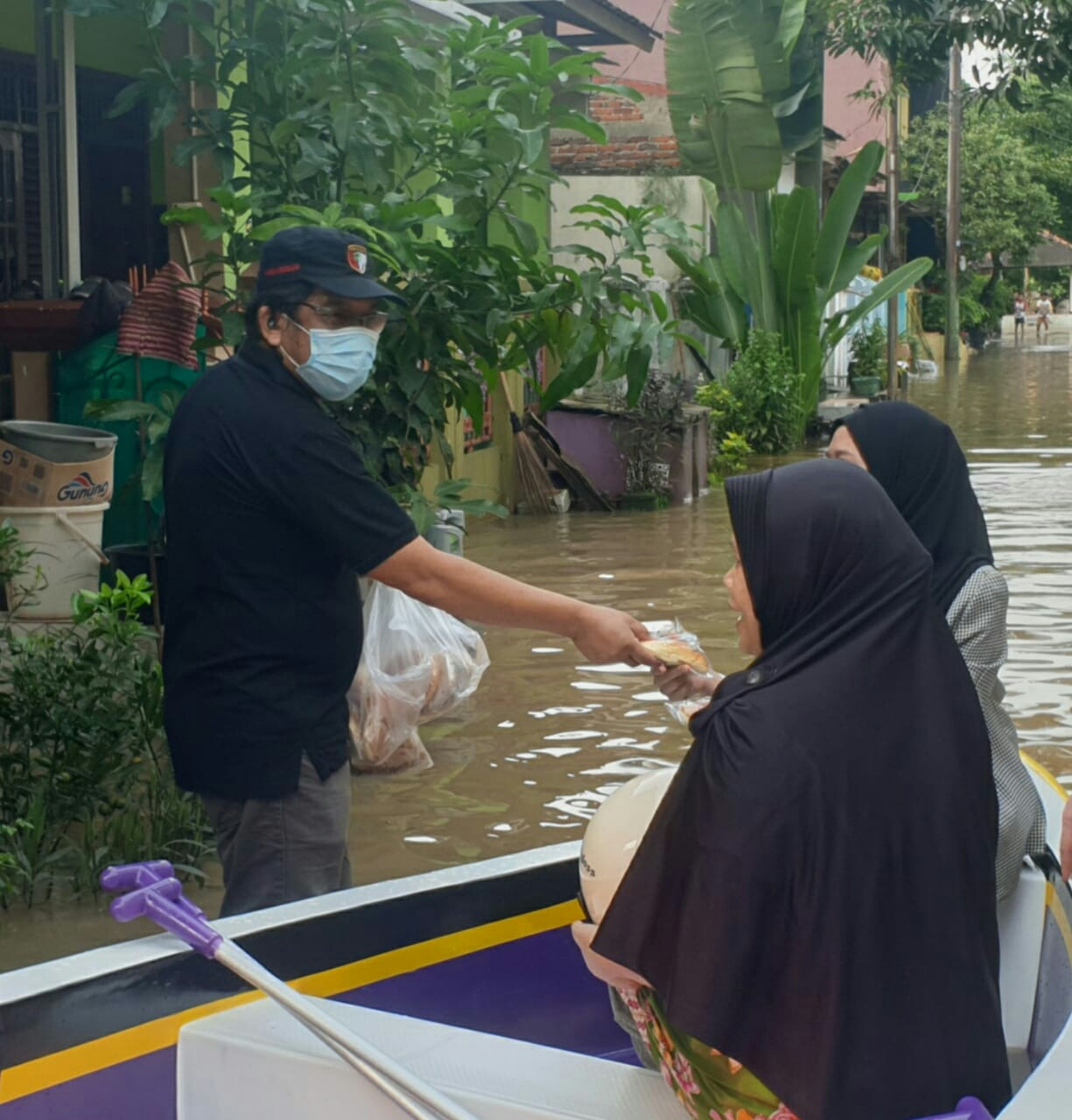 Ketua DPD PKS Kabupaten Tangerang Rispanel Arya saat memberikan makanan kepada korban Banjir di Perumahan Binong, Kecamatan Curug, Kabupaten Tangerang.