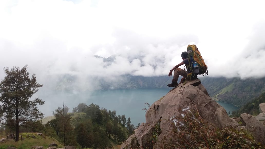 Reza Nufa, 31, sedang menatap keindahaan alam dari Puncak Gunung Rinjani.