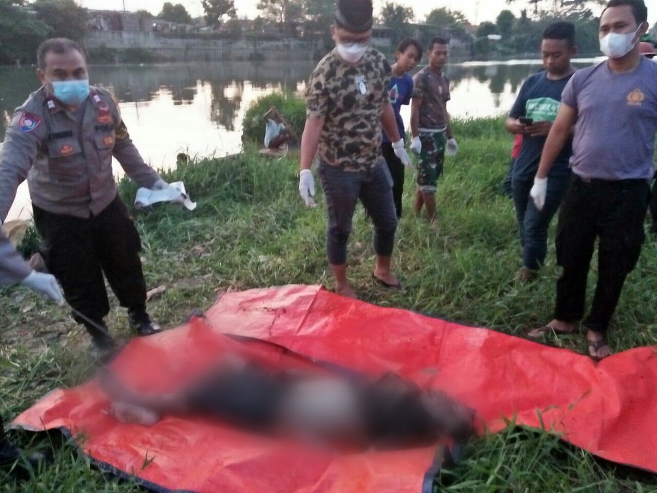 Sesosok mayat laki - laki terapung di bibir Sungai Cisadane saat di evakuasi, Jumat 25 Juni 2021