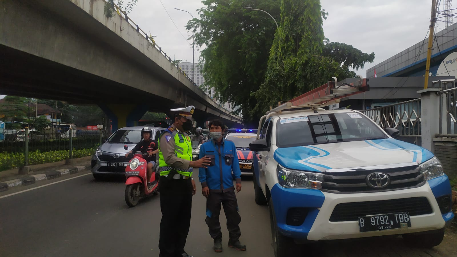 Anggota Satlantas Polres Metro Tangerang Kota saat berdialog dengan petugas PLN yang terparkir di trotoar Jalan Jenderal Sudirman, Kota Tangerang.